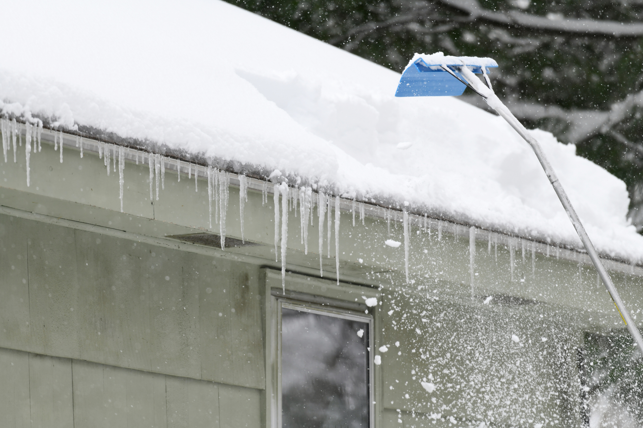 Roof rake removes snow from home roof