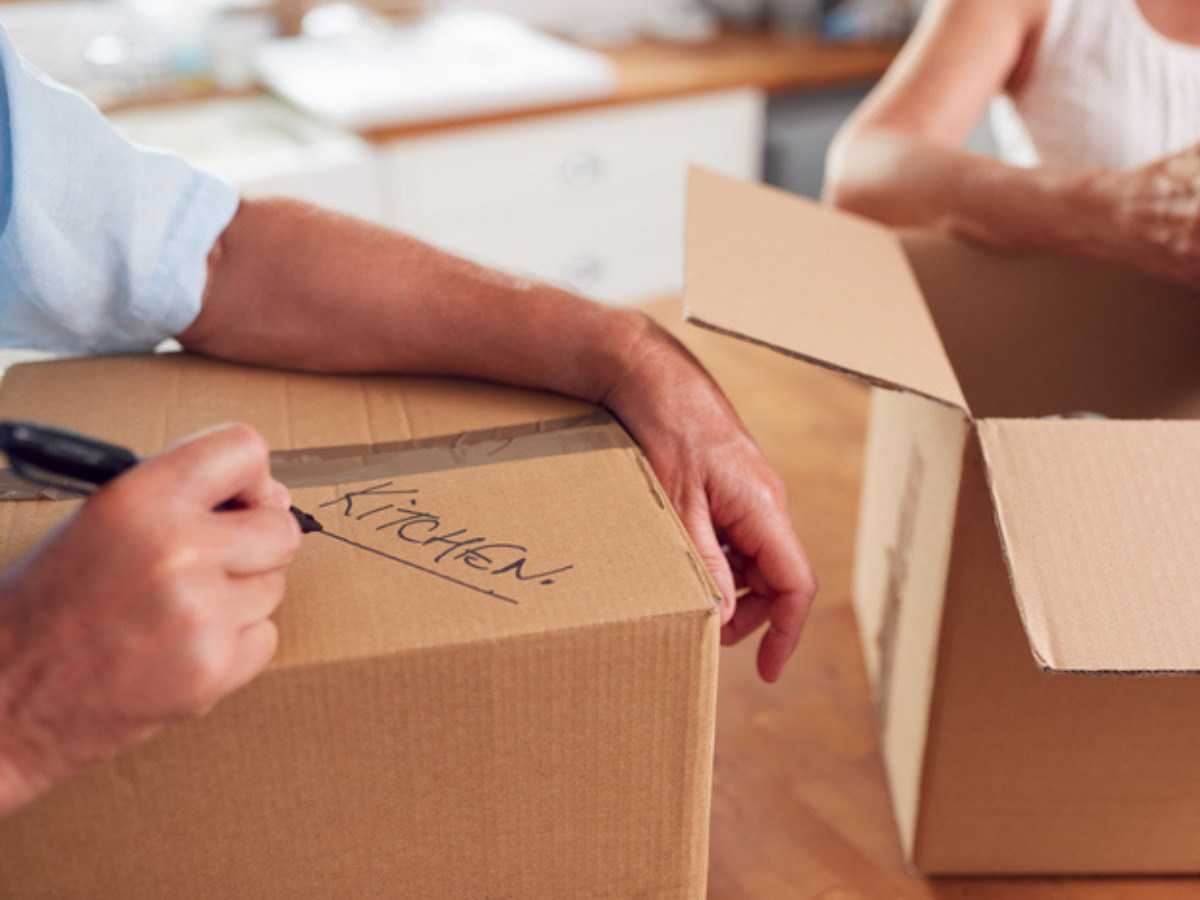 People put their belongings into boxes in preparation to move homes, labelling as they go