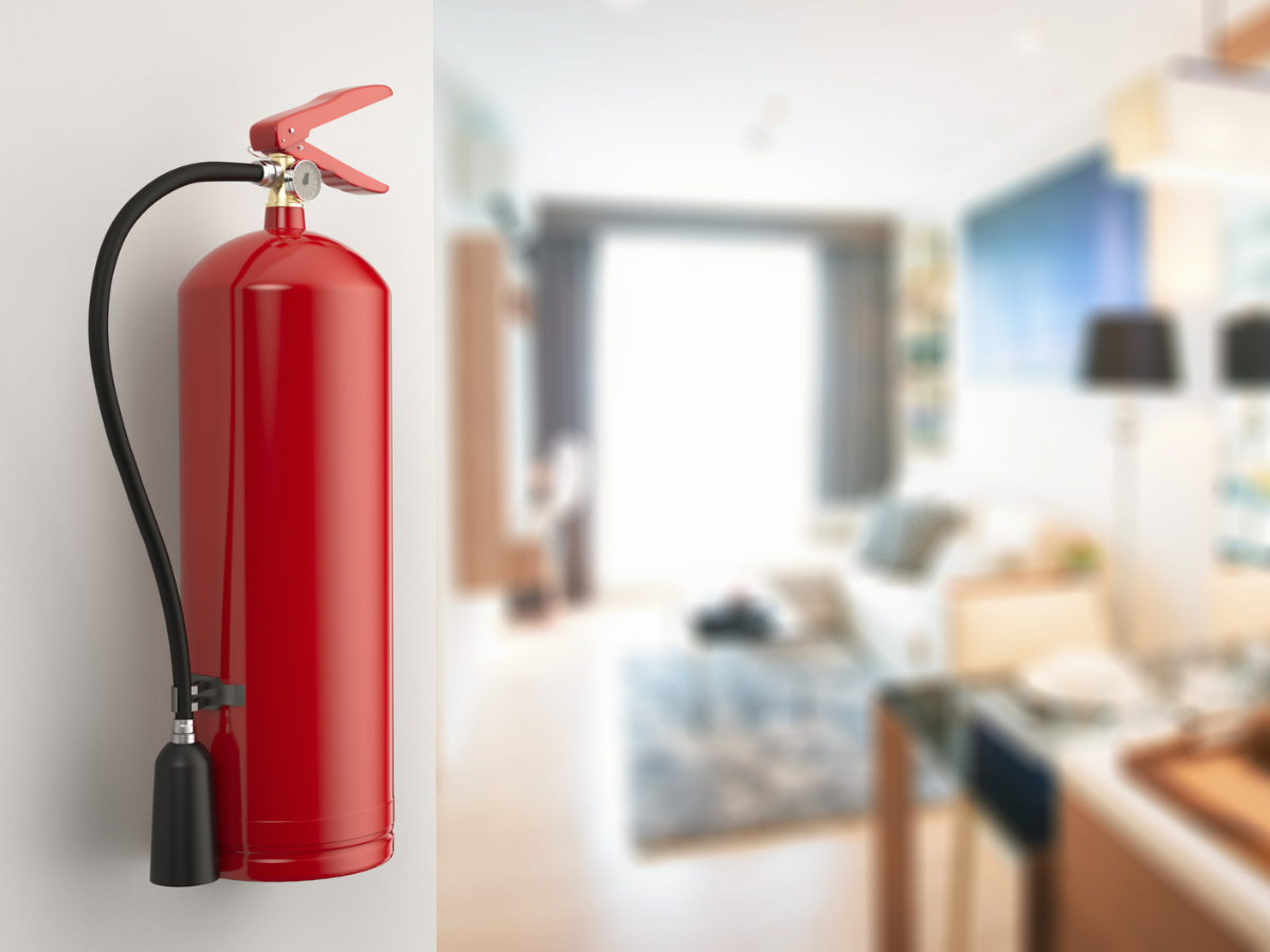 Fire extinguisher mounted on a wall inside a condominium unit for Condo Fires preparedness.