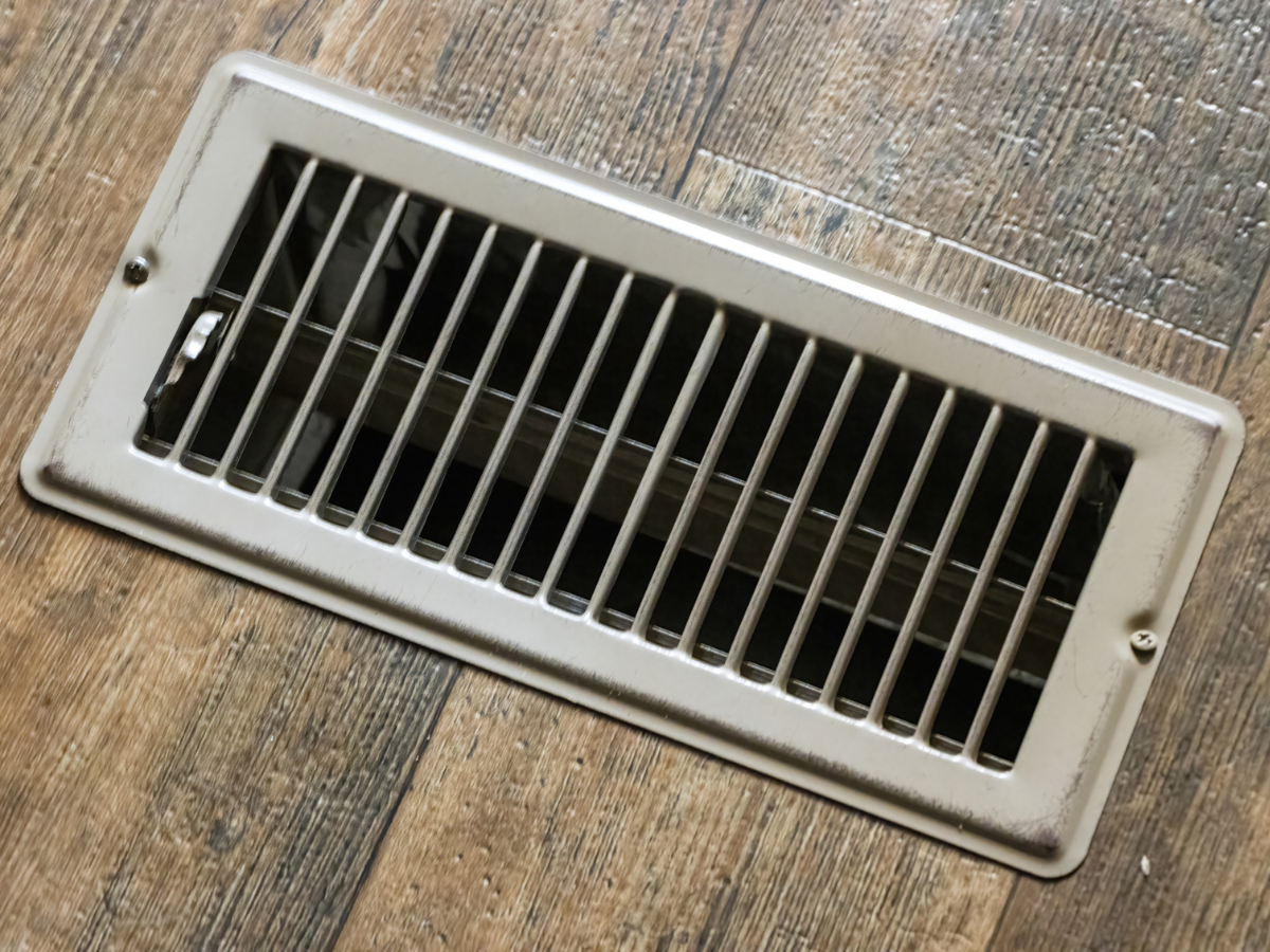 Residential HVAC floor vent installed in hardwood flooring