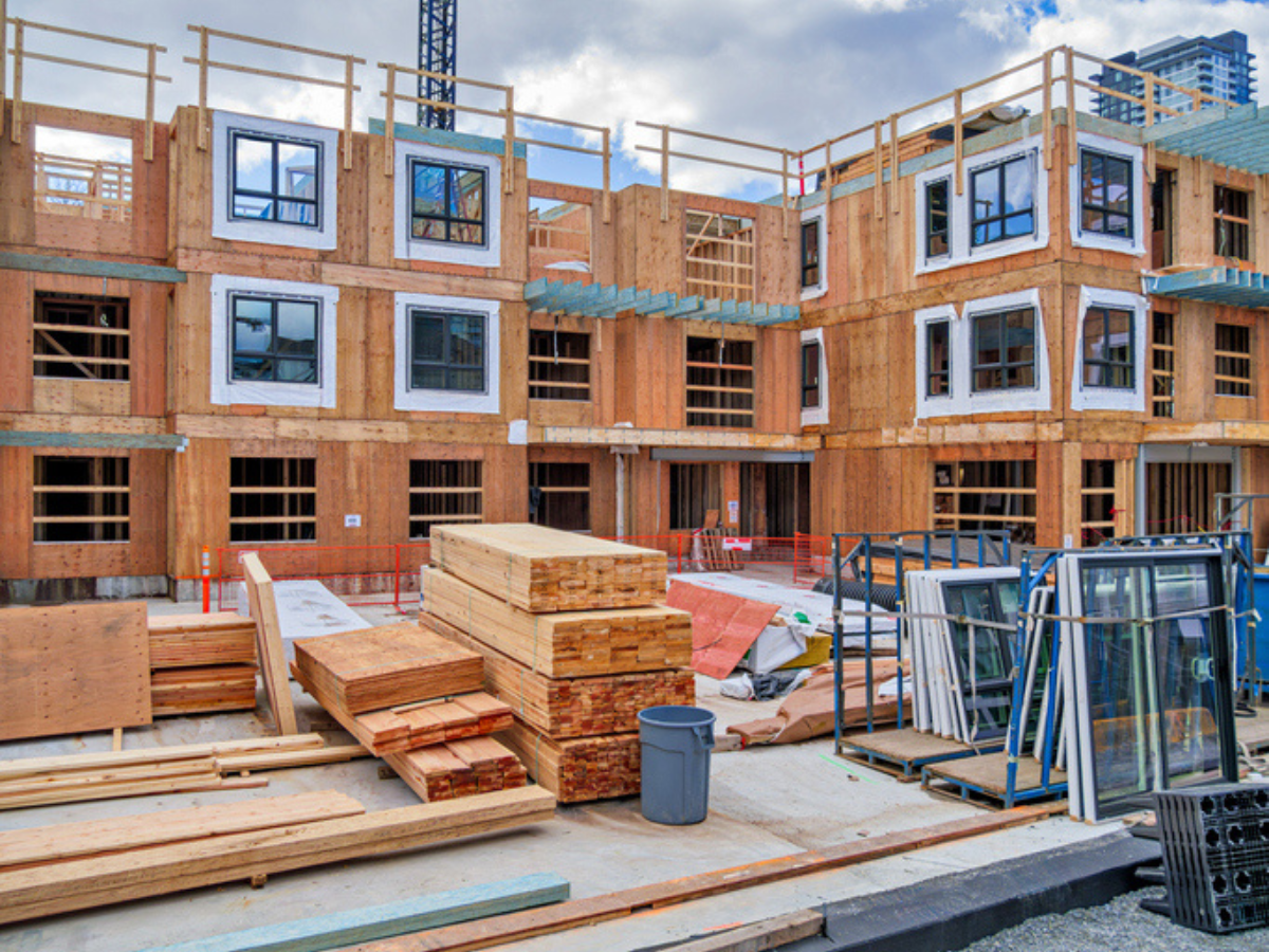 A multi-story residential building under construction with building materials onsite needing builder's risk insurance coverage.