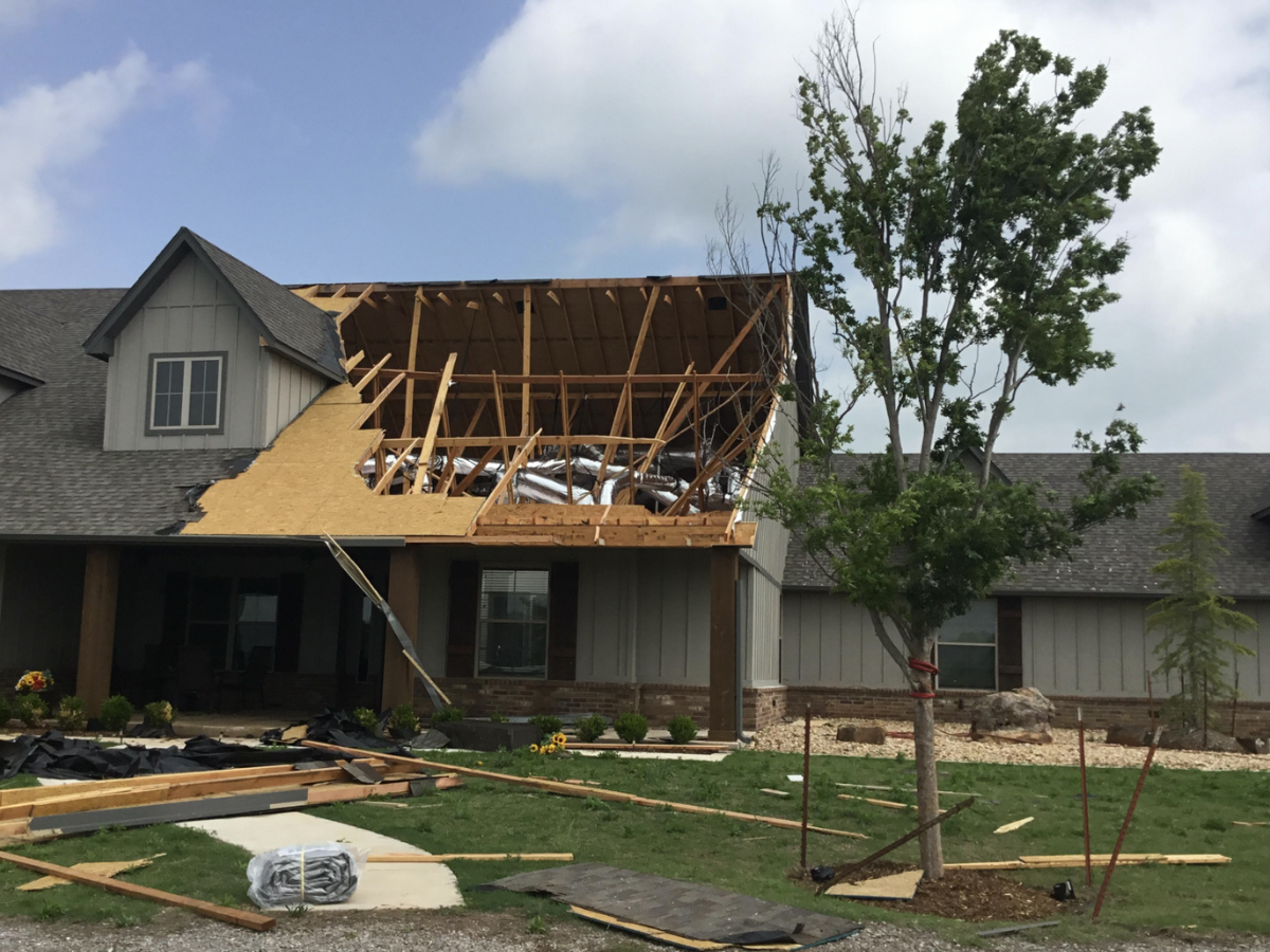 A house with severe roof damage from a storm, demonstrating why builders risk insurance is vital during construction.