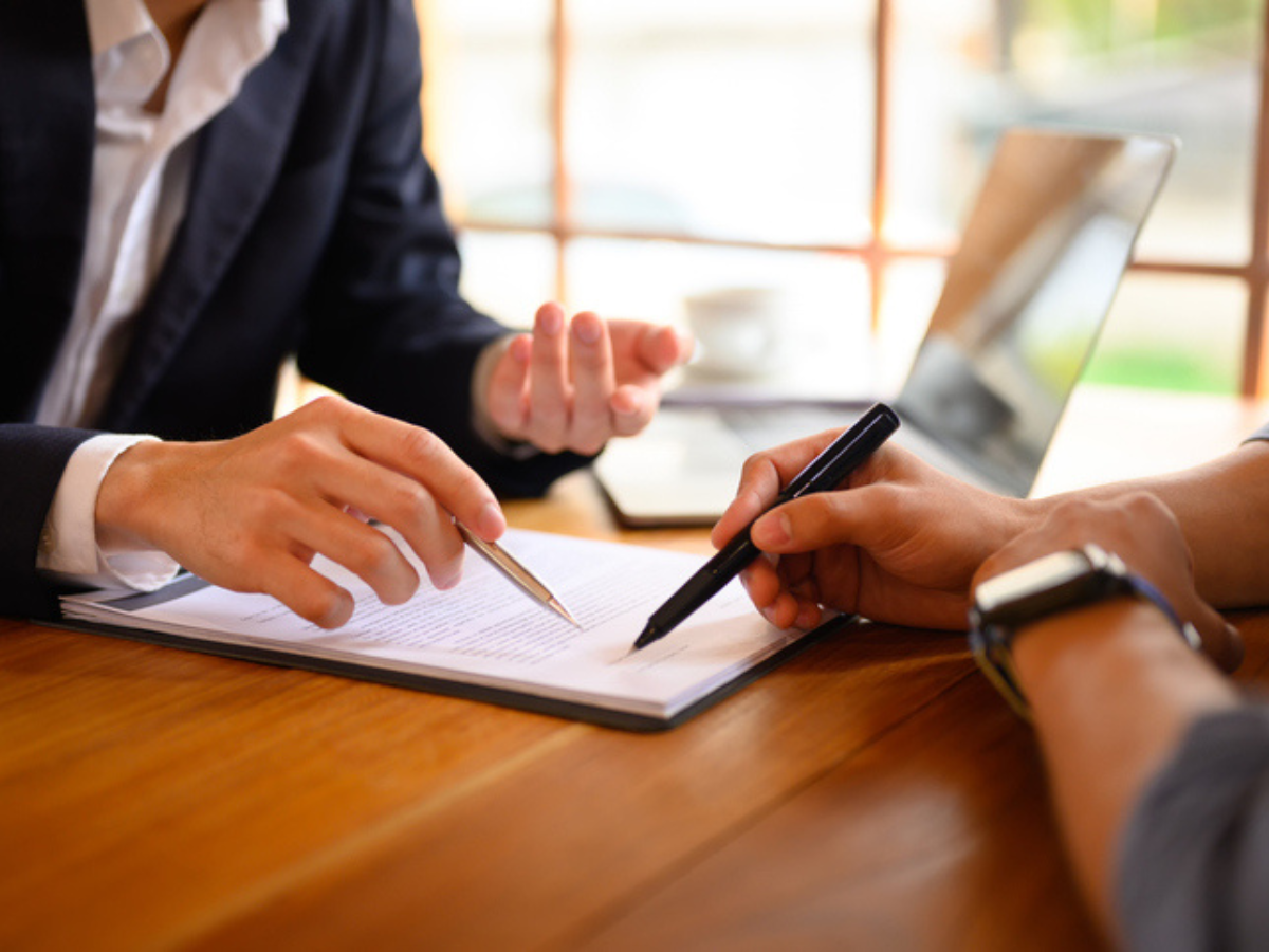 Client and advisor reviewing and signing documents for a business insurance policy in BC. 