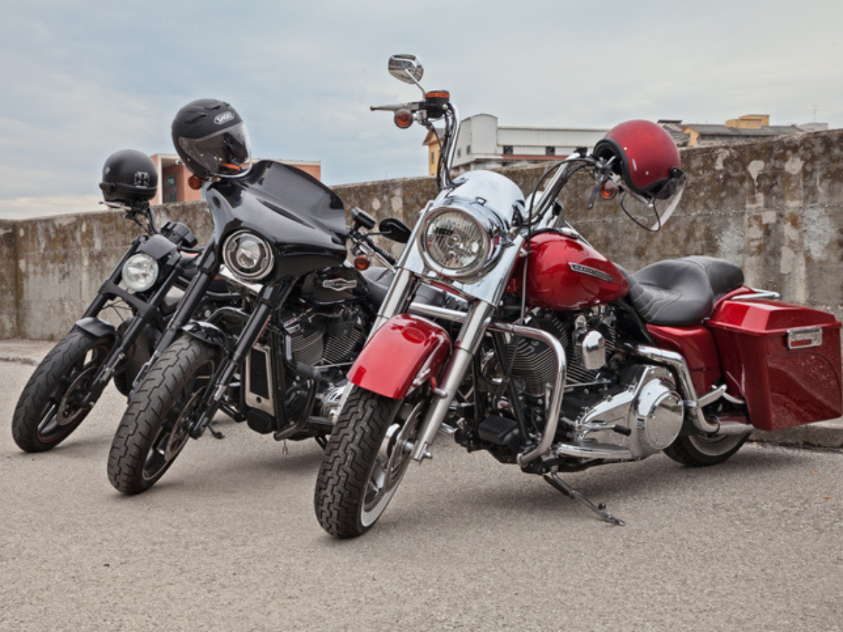 Red and black Motorcycle bikes parked outdoors with helmets attached