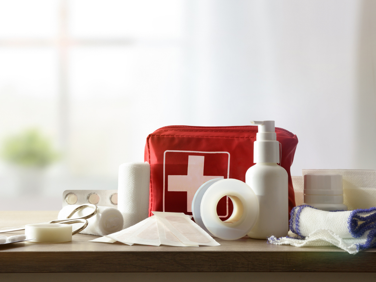 Emergency first aid kit supplies arranged on a table for Cabin and Cottage safety planning.