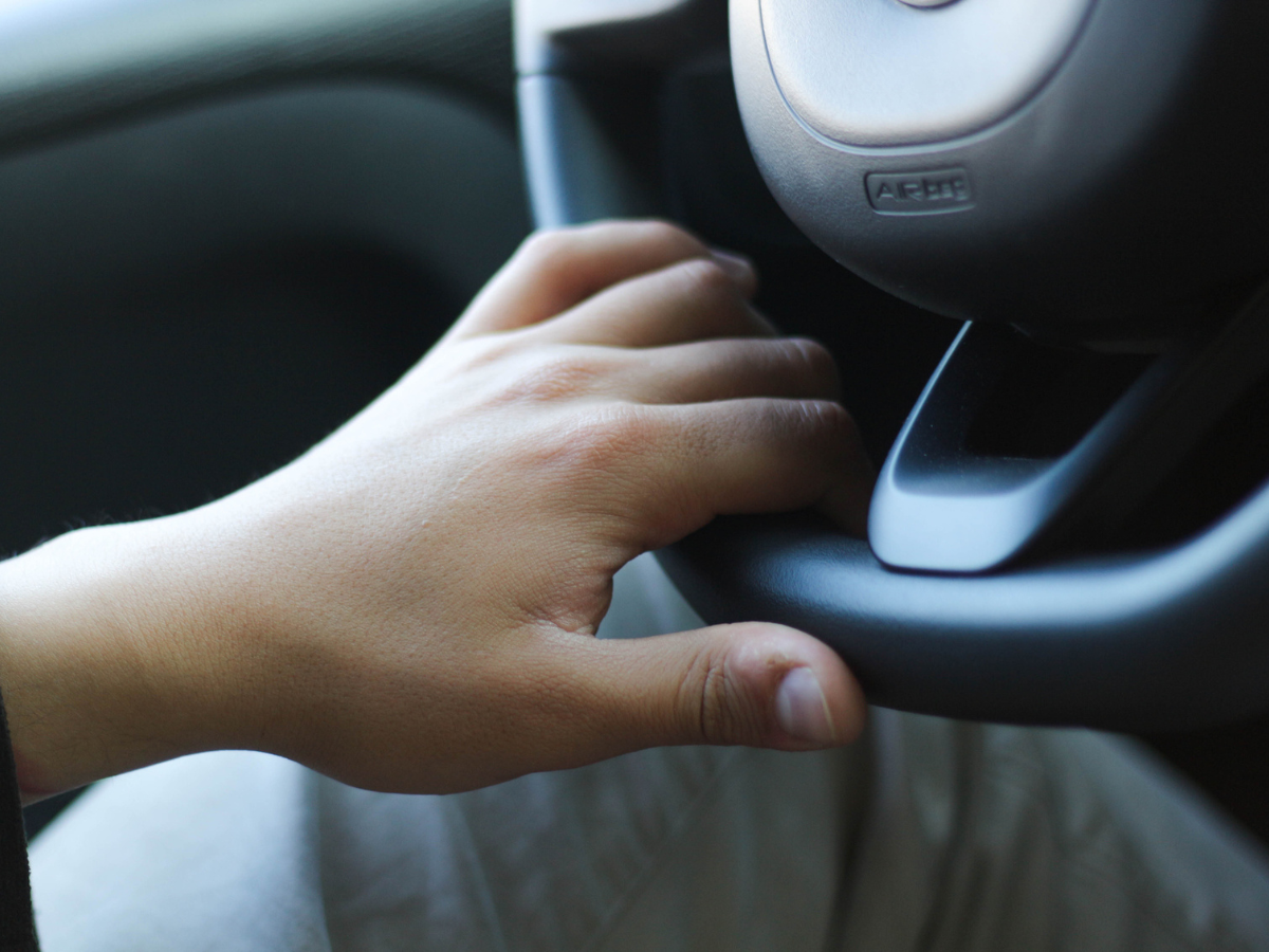 Driver holding an RV steering wheel while navigating toward a Camp destination