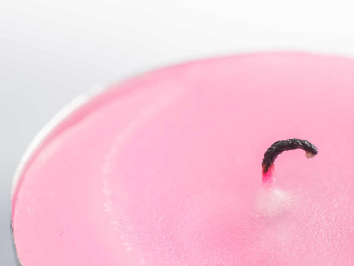 Pink Candle featuring a curved black wick