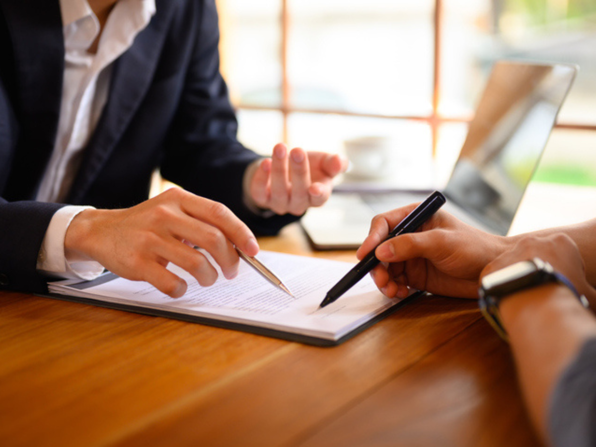 Business professionals reviewing and signing documents, symbolizing the process of securing commercial car insurance coverage in Western Canada.