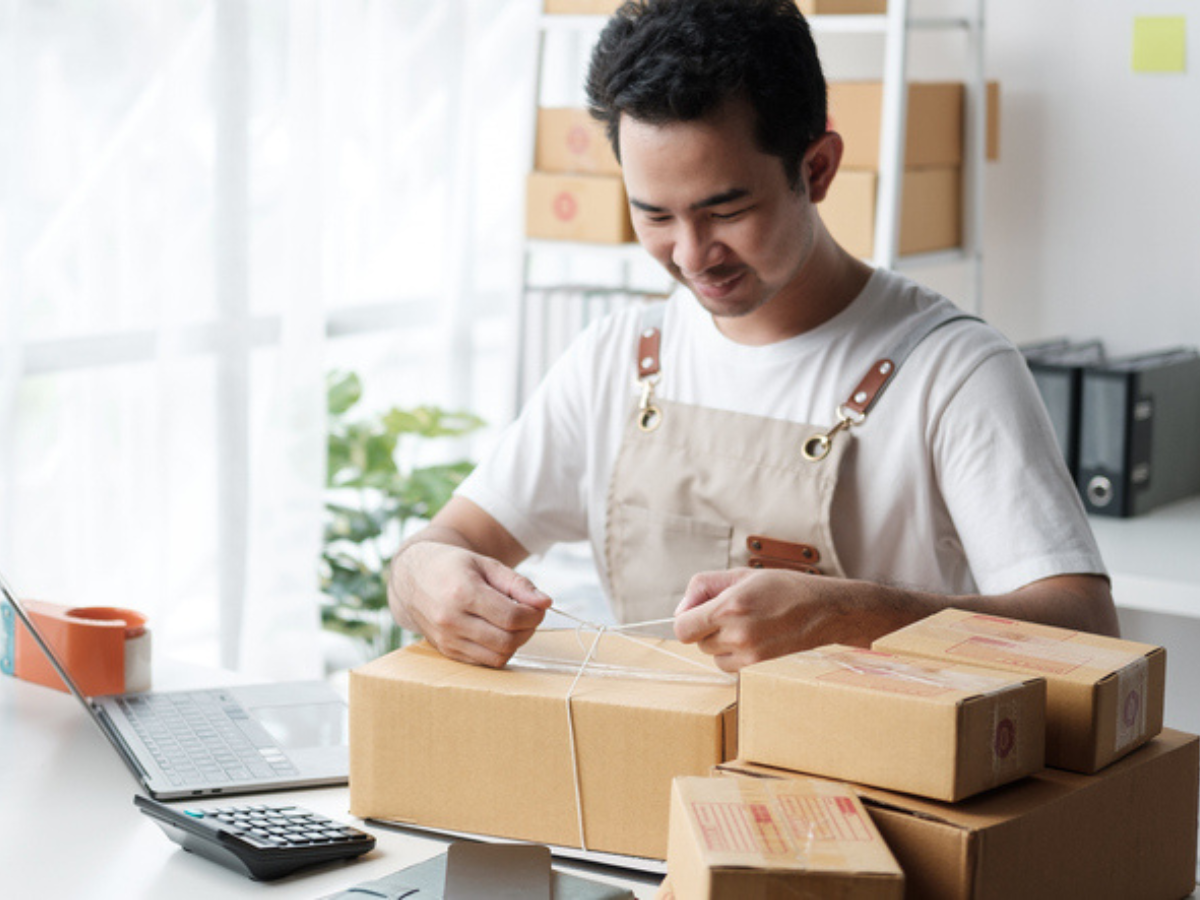Small business owner preparing customer packages in a home office - an example of why it’s important to have business insurance protecting your inventory. 