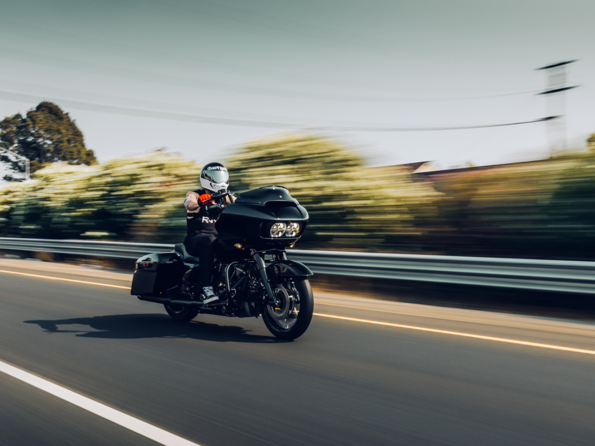 Motorcycle rider cruising on an open highway with blurred scenery highlighting speed and movement