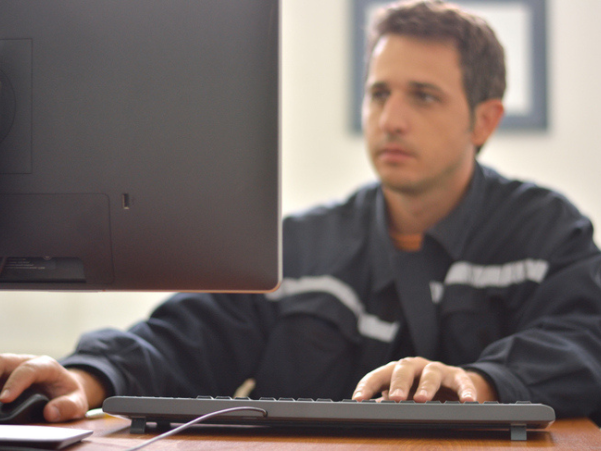Tradesperson on computer in contractor's shop with cyber insurance