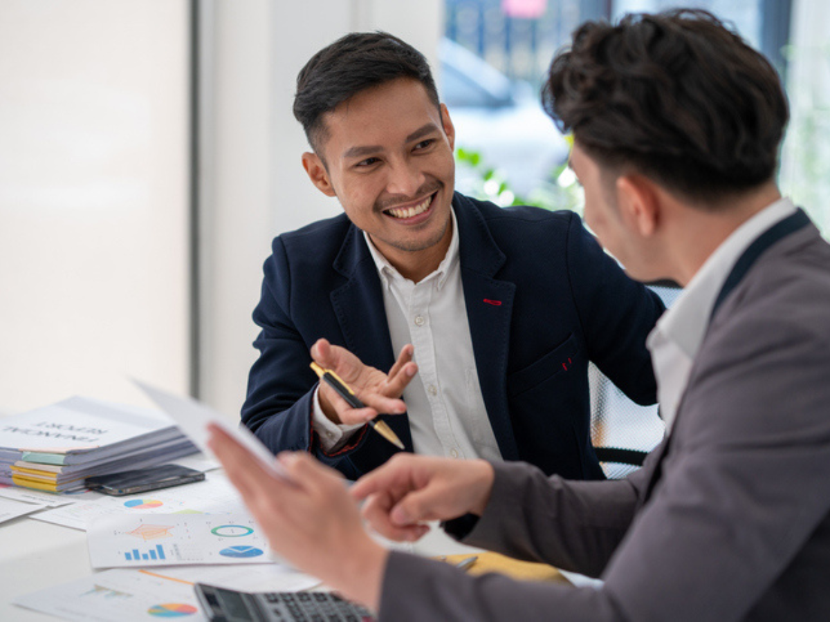 Insurance broker and client discussing optional commercial car insurance coverages, such as increased liability limits and loss of use protection, to better safeguard business vehicles.