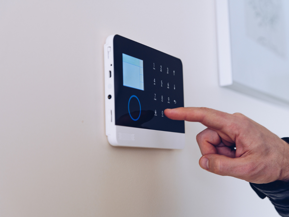Digital alarm system being armed to help protect a home while away on vacation.