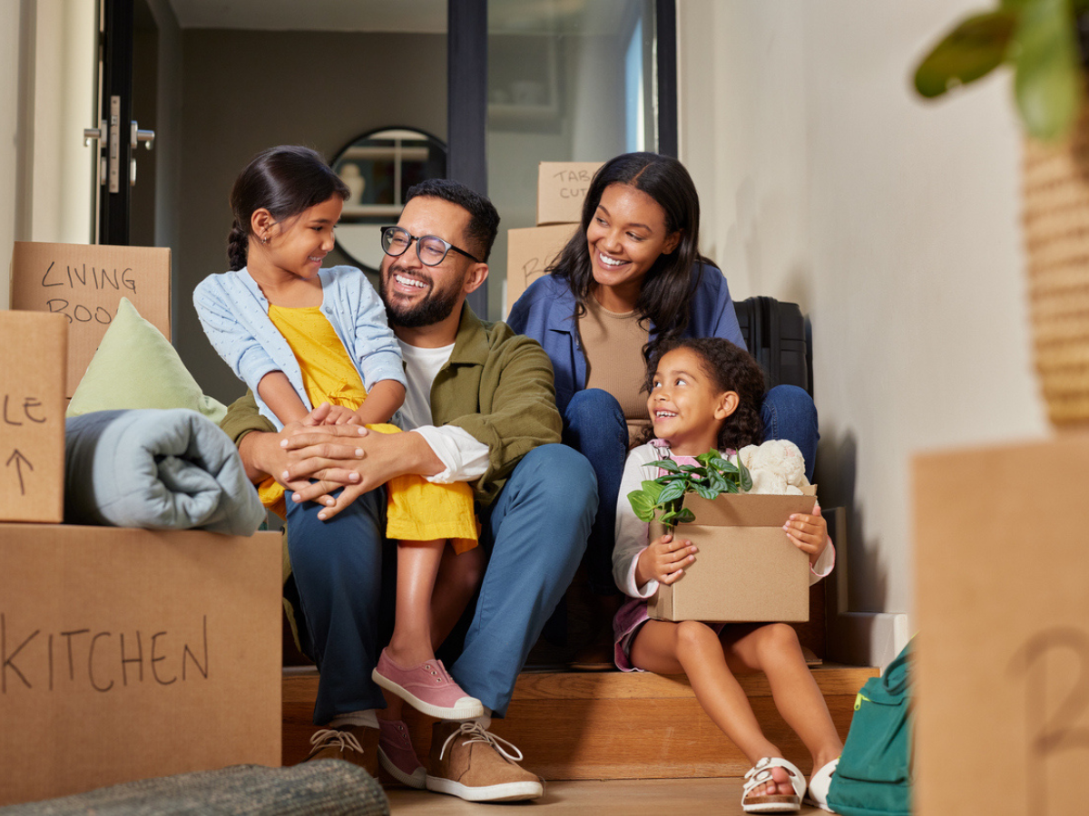 Happy family sitting among moving boxes in a new home