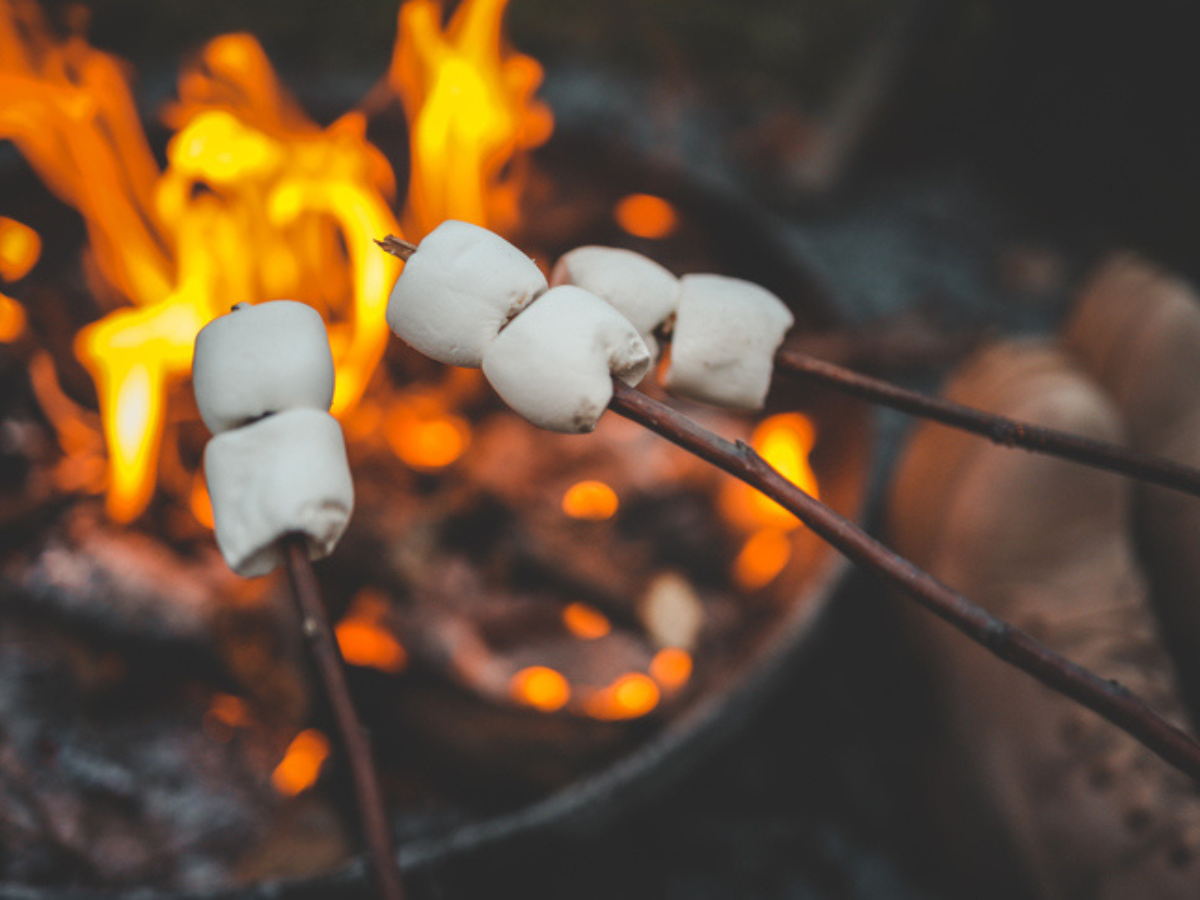 Marshmallows roasting over an open fire pit, reminding us of the joys of summer nights and the importance of practicing fire pit safety to keep gatherings safe and fun.