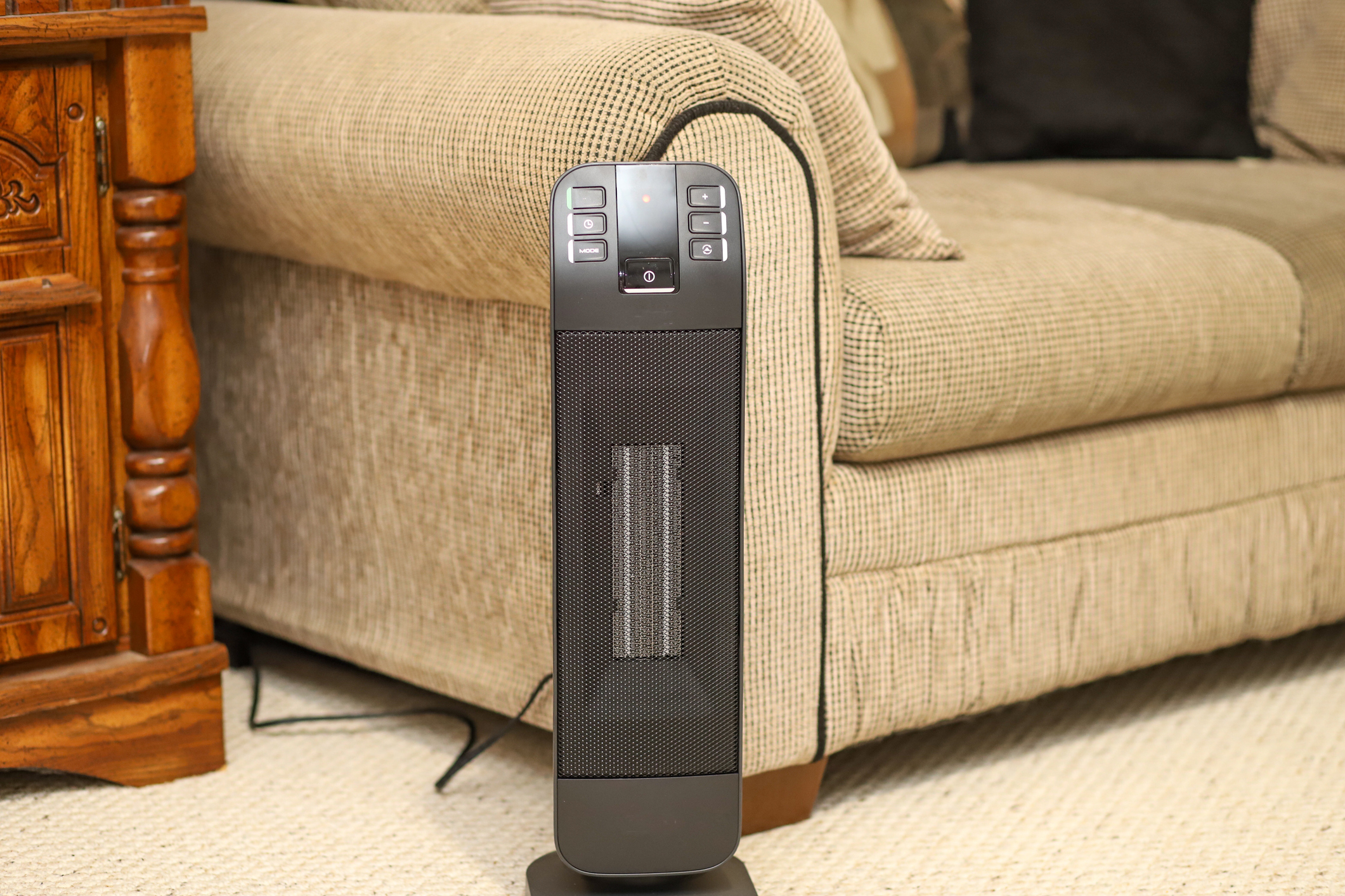 A space heater in front of a couch.