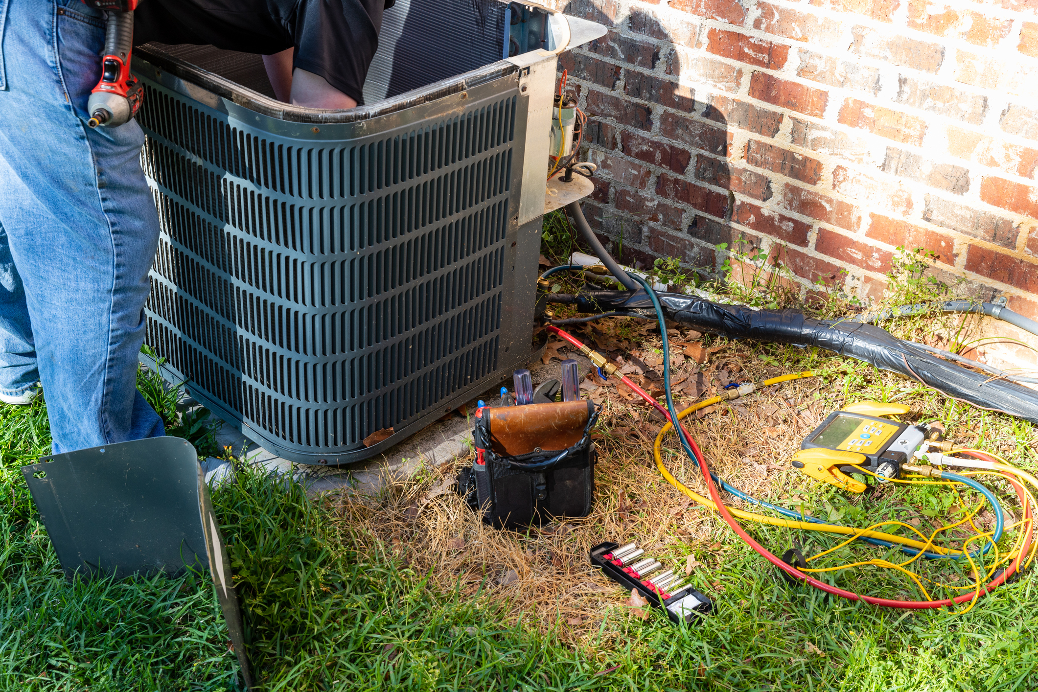 Maintenance being performed on outdoor air conditioning unit