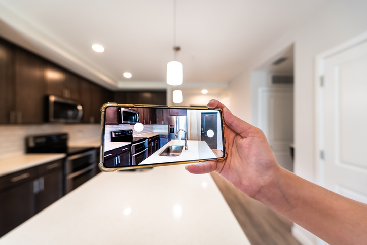 Tenant on a rental tour taking pictures of the suite