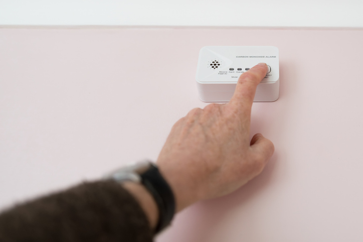 Homeowner regularly testing their carbon monoxide alarm