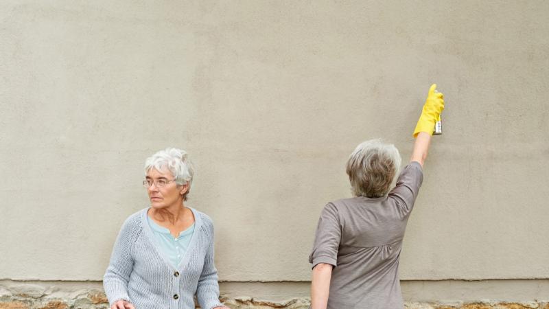 People spray painting a wall