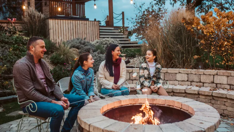 family with sandbox insurance sitting around a fire