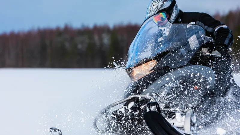 Snowmobile rider speeding through snow in Saskatchewan winter with Sandbox snowmobile insurance