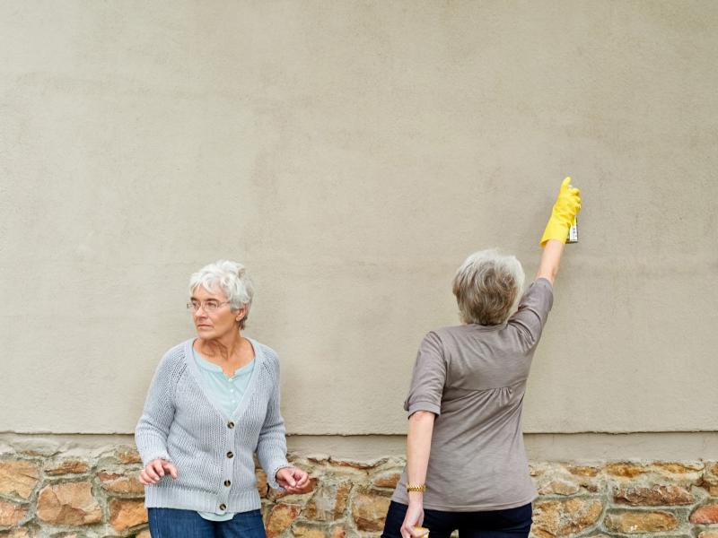 People spray painting a wall