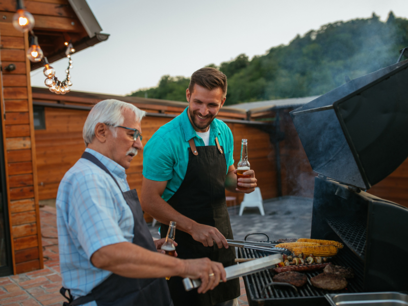 Two people using a BBQ