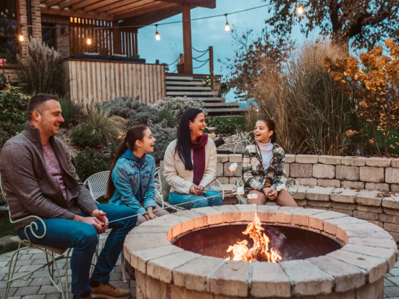 family with sandbox insurance sitting around a fire