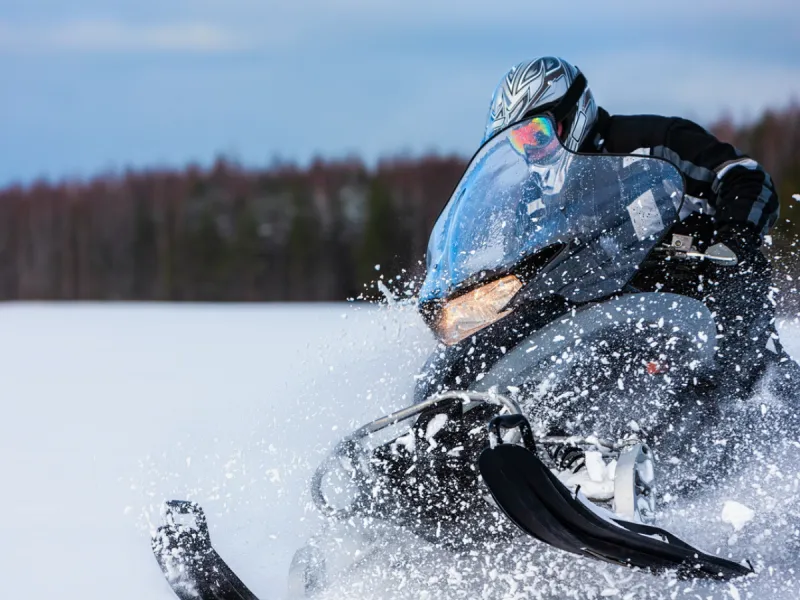 Snowmobile rider speeding through snow in Saskatchewan winter with Sandbox snowmobile insurance