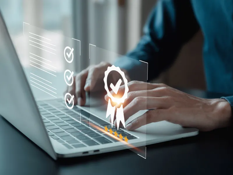 Hands typing on laptop with quality guarantee graphic.